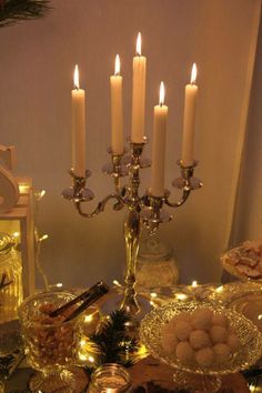 a table topped with lots of food and lit candles