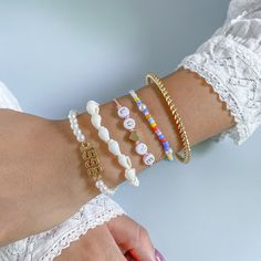 Crafted from pearl, howling and shell, these bracelets beautifully complement your favorite ensembles. Includes 18k gold-plated and white '1999' bracelet, white shell bracelet, pink and white 'love' bracelet, orange and blue beaded bracelet and 18k gold-plated bangle (five bracelets total) Full graphic text 18k gold-plated and white '1999' bracelet): 1999. Full graphic text (pink and white 'love' bracelet): Love. Lobster claw clasp 18k gold-plated copper / acrylic / teal howlite / pearl / shell Trendy White Charm Bracelet With Round Beads, Trendy White Name Bracelet As Gift, Trendy White Name Bracelet For Gift, White Name Bracelet Bangle For Friendship, White Friendship Name Bangle Bracelet, Everyday White Pearl Jubilee Bracelet, Gold Casual Jewelry For Valentine's Day, Casual Gold Jewelry For Valentine's Day, Adjustable Trendy Pearl White Jewelry