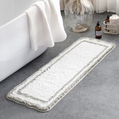 a white bath mat sitting on top of a bathroom floor