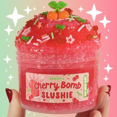 a person holding up a plastic container filled with fruity bomb slushie and sprinkles