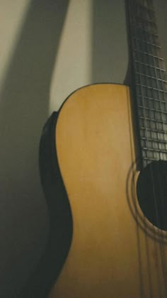 an acoustic guitar is sitting on the floor