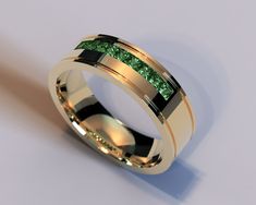 a gold ring with green cubics on the inside and inlayed to it