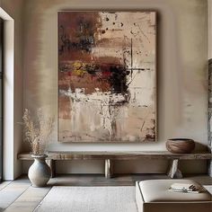 an abstract painting hangs on the wall above a bench and ottoman in a living room