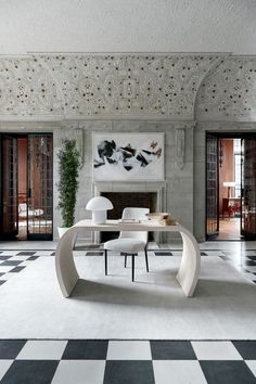 an elegant dining room with black and white checkered flooring, large painting on the wall