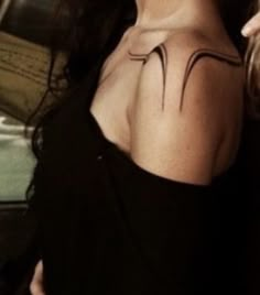 a woman with a tattoo on her shoulder