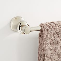 a towel is hanging on the wall next to a toilet paper holder with a button