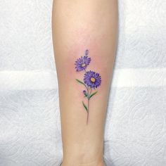 a purple flower tattoo on the ankle