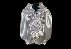 "Elevate your wardrobe with this sophisticated white satin blouse featuring intricate ruffles and puffy sleeves. The luxurious satin fabric excudes elegance, while the carefully designed ruffles add a touch of femininity. Closure with zipper at front.  You can choose between black trimming of the ruffles ( like on the photos ) or whole white. SIZE S - US 6, UK 8, EU 36 bust: bust around 34.5\"/90cm Waist: waist around 27.5\"/70cm Hips: hips around 34.5\"/90cm SIZE M - US 8, UK 10, EU 38 bust: bust around 37.5\"/95cm Waist: waist around 29.5\"/75cm Hips: hips around 37.5\"/95cm SIZE L - US 10, UK 12, EU 40 bust: bust around 39.5\"/100cm Waist: waist around 31.5\"/80cm Hips: hips around 39.5\"/100cm SIZE XL - US 12, UK 14 , EU42 bust: bust around 41.5\"/105cm Waist: waist around 33.5\"/85cm White Silk Top With Ruffles, White Ruffled Evening Top, Formal Blouse With Ruffles And Ruffled Collar, White Puff Sleeve Blouse With Ruffles, White Ruffled Collar Blouse With Ruffles, Evening Satin Blouse With Ruffles, Wedding Blouse With Ruffles And Ruffled Collar, Formal Ruffled Puff Sleeve Blouse, Formal Puff Sleeve Blouse With Ruffles