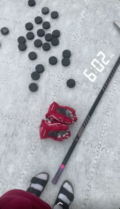 a hockey goalie's helmet and stick laying on the ground next to some black rocks