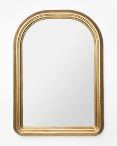 a gold framed mirror against a white wall with an arch shaped mirror in the middle