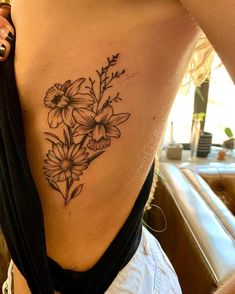 a woman's lower back tattoo with flowers on it