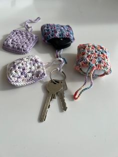 four crocheted key fobs on a white surface