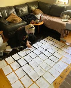 a living room filled with lots of papers on top of a floor next to a couch