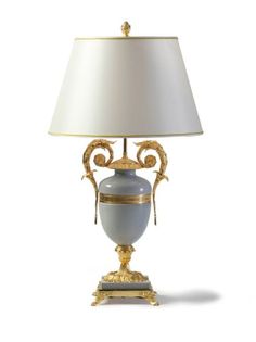 a lamp that is sitting on top of a white surface with a gold trimming