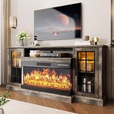 an entertainment center with a fire place in front of the tv on top of it