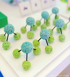 small green and blue pom - poms sitting on top of a white table