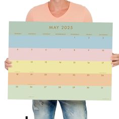 a woman is holding up a calendar for may