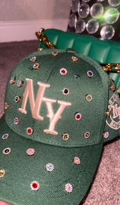 Adjustable NY Custom Bedazzled Hat customed by ShanayCosmetics Comes in 2 colors: Black or Green More colors COMING SOON....  PLEASE KEEP IN MIND THAT I AM NOT RESPONSIBLE FOR ANY DELAYS WITH SHIPPING ONCE I HAVE DROPPED YOUR PACKAGE OFF AT THE POST OFFICE! THAT IS OUT OF MY CONTROL. PLEASE BE AWARE I AM NOT RESPONSIBLE FOR ANY LOST, DAMAGED OR STOLEN PACKAGES!! Custom Fitted Hats Drawings, Cheap Fitted Costume Hats And Headpieces For Parties, Bling Baseball Caps For Women, Luxury Custom Black Hat, Luxury High Crown Hats With Rhinestones, Fitted Hats With Name, Custom Fitted Hats Pink, Luxury Fitted Hat For Events, Luxury Rhinestone Hats With Curved Brim