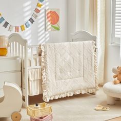 a white crib with a teddy bear in it