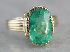 "This vintage emerald ring is a simple, and quite a versatile piece with clean lines and great proportions. This ring is classic and traditional, featuring a solid gold head to hold the stone securely. The beautiful emerald has a shade of green that is just the same as the brightest springtime leaves. Metal: 14K Yellow Gold Gem: Emerald 4.08 Carats Gem Measurements: 12.1 x 8.5 mm, Oval Ring Size: 6 Marks: \"KIMBERLY 14K\" Stamped on the inside band SKU #: 3LWN4FJ2 Each piece has been identified Elegant 14k Stamped Emerald Ring, Elegant Green Emerald Ring With Round Band, Classic Green Diamond Ring With Bezel Setting, Classic Signet Ring With May Birthstone, Timeless Green Emerald Ring With Bezel Setting, Timeless Bezel-set Emerald Ring For May Birthstone, Timeless Emerald Ring With Bezel Setting For May Birthstone, Classic Solitaire Diamond Ring For May Birthstone, Timeless Bezel Set Emerald Ring For May Birthstone