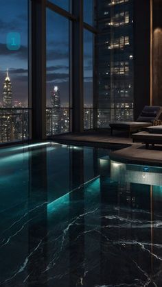 an indoor swimming pool in front of a large window overlooking the city skyline at night