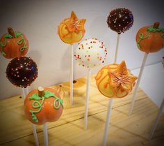 there are many pumpkins on the sticks with icing and sprinkles