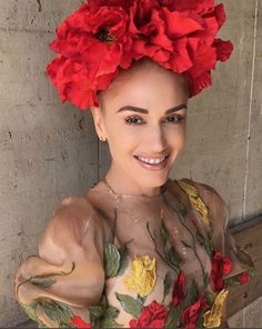 a woman with red flowers on her head and hair in the shape of a flower