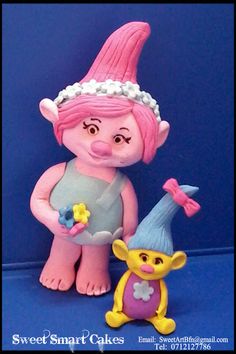 a pink troll doll next to a yellow and blue gnome figurine on a blue background