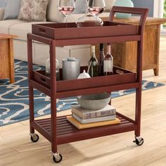 a wooden serving cart with wine glasses on it