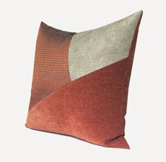 an orange and brown pillow with two different colors on it's side, sitting against a white background