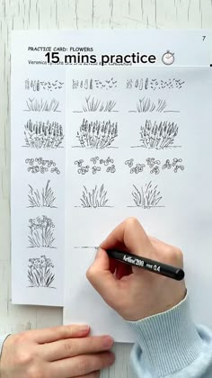 someone is drawing plants on paper with a marker and pen in front of the page