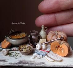 a person holding their hand over some food on a table with other items around it