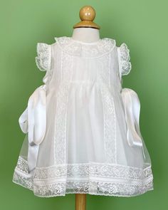 A delicate and romantic dress, made with lightweight white organza with laces. It has satin ribbons on the sides. It has buttons on the back for closure, and it comes with a matching bonnet. Made in Spain Dry clean Final sale, no exchanges nor returns are available White Christening Dress, White Baptism Dress, Baptism Dresses, Christening Dresses, Dress For Baby Girl, Organza Lace, Spanish Fashion, Dress For Baby, Baptism Dress