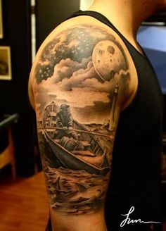 a man with a boat and moon tattoo on his arm