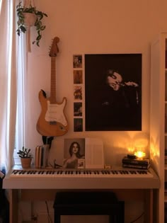 a room with a piano, guitar and various pictures on the wall next to it