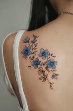 the back of a woman's shoulder with blue flowers on it