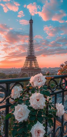 the eiffel tower is in the distance with pink flowers growing out of it