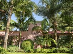 a pink building with palm trees in front of it