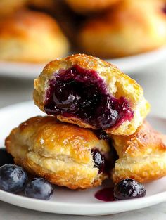 two blueberry scones stacked on top of each other with the rest of the scones in the background