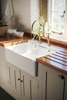 a white kitchen sink sitting under a window