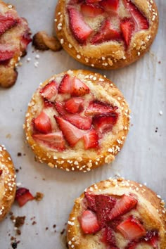 strawberry shortcakes with powdered sugar and sprinkles are arranged on a baking sheet