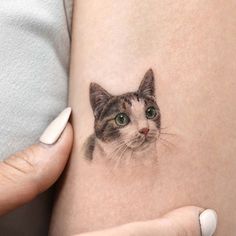 a woman's leg with a tattoo of a cat on the side of her thigh