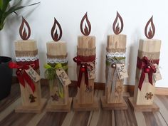 four wooden candles with ribbons and bows on them