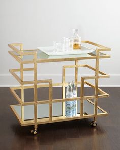 a gold bar cart with drinks on it