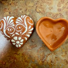 two heart shaped bowls sitting on top of a table