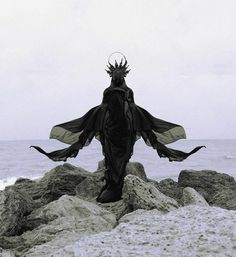 a person standing on some rocks near the ocean