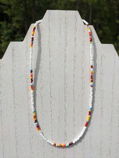 "This delicate ~16 inch necklace is the perfect complement to your favorite sweater, or a unique statement piece for Halloween, Thanksgiving, or any other day of the year. It was handmade with white, orange, yellow, brown, red, and light blue glass seed beads, and finished with a ~3 inch silver-toned adjustable necklace chain, lobster clasp closure, crimp beads, and jump rings.  This piece has the flexibility to act as a standalone item or as a layer in a necklace set you already own. All BullCi White Bohemian Beaded Necklace As Gift, White Single Strand Beaded Necklace For Festival, White Necklaces With Spacer Beads For Festival, Bohemian White Beads As A Gift, Colorful Beaded White Jewelry For Crafting, White Single Strand Bohemian Beaded Necklace, Spiritual White Necklaces With Tiny Beads, White Bohemian Single Strand Beaded Necklace, White Jewelry With Colorful Beads For Crafting