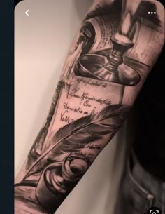 a man's arm with an ink pen and quill on the cover up