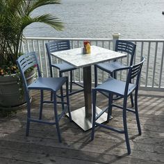 a table and chairs on a deck overlooking the water