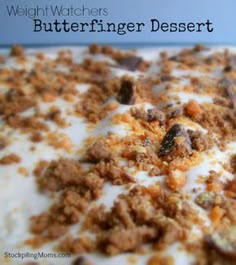 a close up view of a dessert with white frosting and crumbled toppings